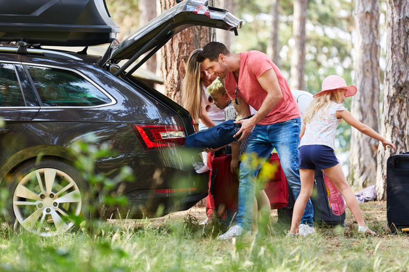 family packing luggage into car