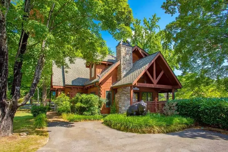 Pigeon Forge cabin named river's edge on a bright summer day surrounded by trees