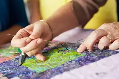 Woman sewing a quilt.