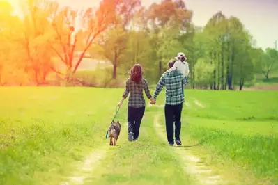 Family walking dog in the park.