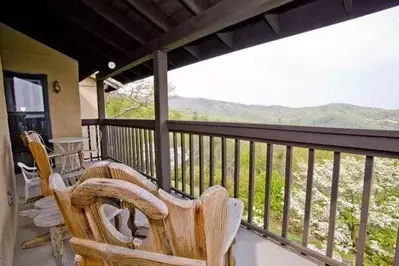 Chairs on the deck of a cabin rental with mountain views.