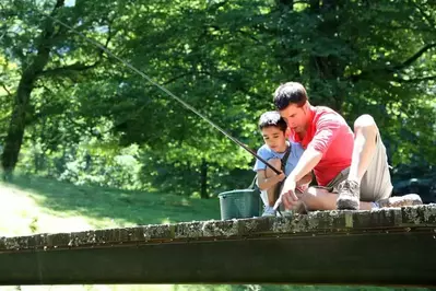 Father and son fishing together in the mountains.