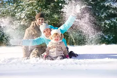 Happy family playing in the snow.