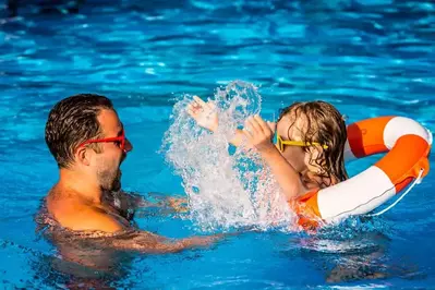 father and daugher enjoying a day of swimming while staying at a cabin in Pigeon Forge with pool access.