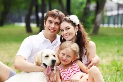 Family in the grass with puppy near their pet friendly Pigeon Forge cabin