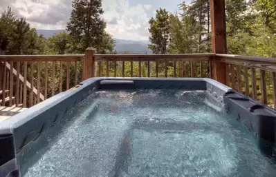 A hot tub on the deck of a Pigeon Forge cabin with mountain views.