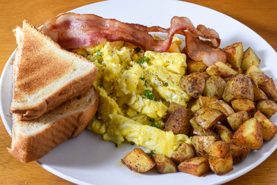 eggs, bacon, toast, orange juice, coffee, and milk