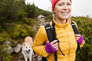 A woman hiking with her dog.