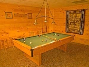 A pool table in a cabin in Gatlinburg TN with a game room.
