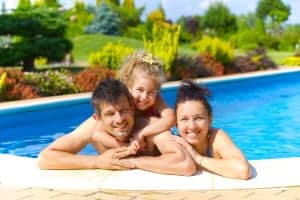 A family posing for a photo in a swimming pool.