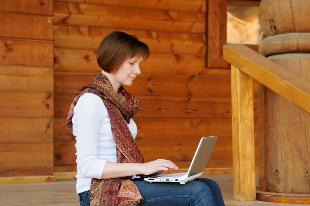 A woman using a laptop at one of our Tennessee Smoky Mountain cabins with WiFi.