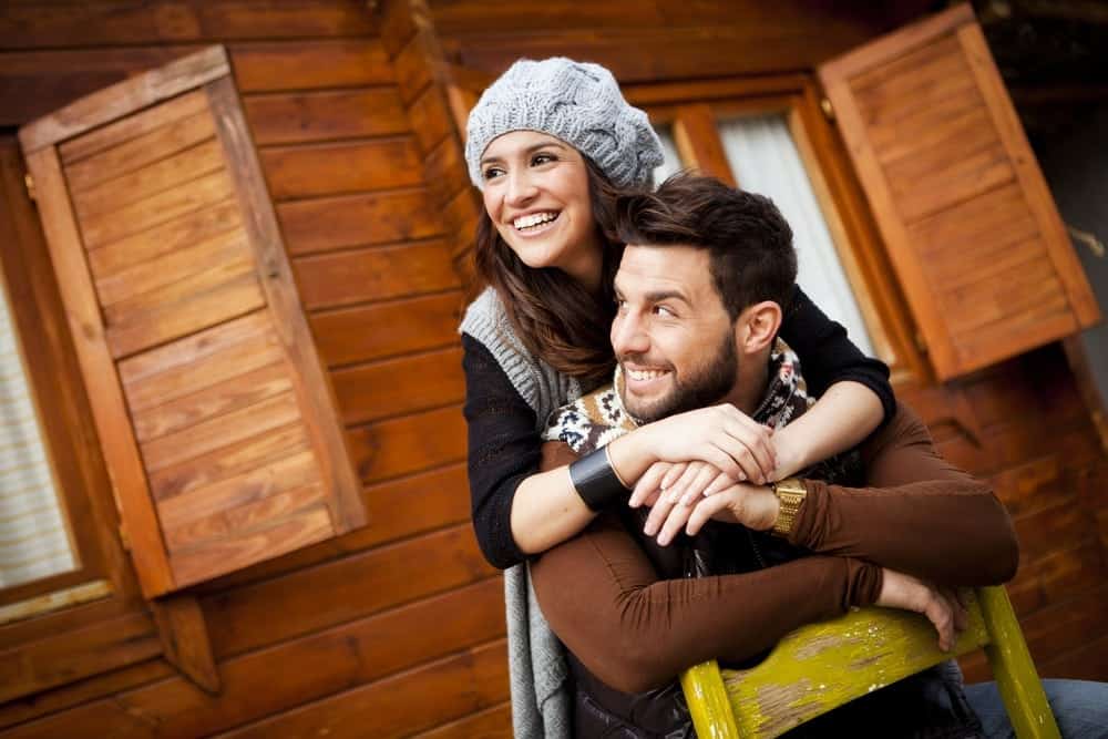 Romantic couple outside of a cabin.