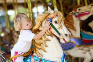 small child petting carousel horse at Dollywood