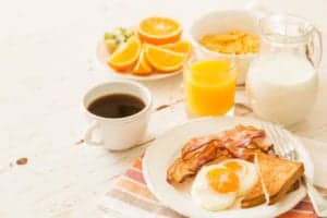 eggs, bacon, toast, orange juice, coffee, and milk