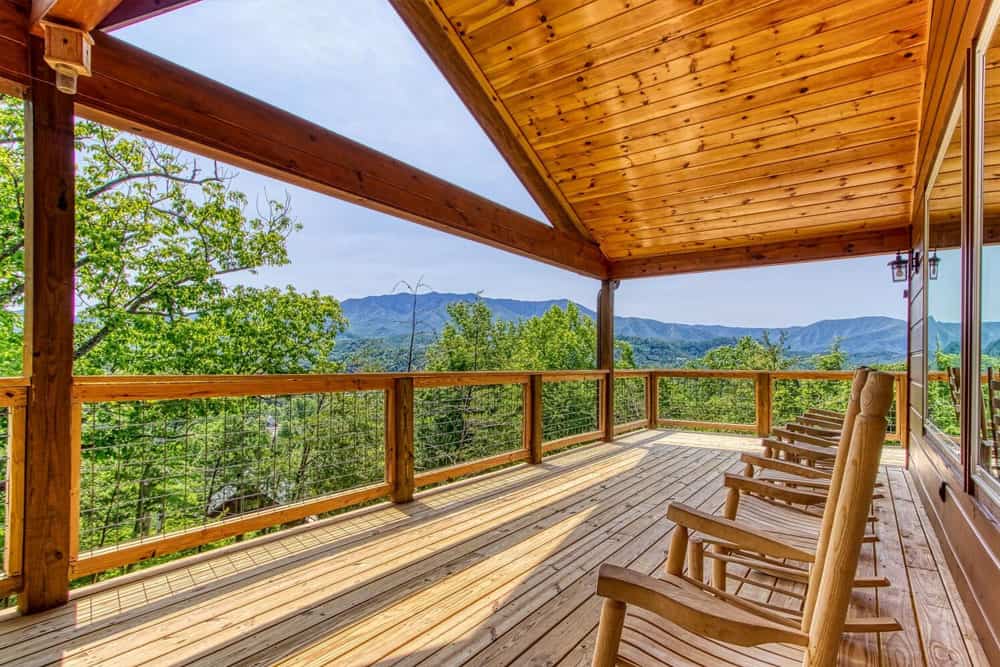 mountain view from a smoky mountain cabin deck with rocking chairs