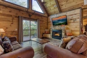 couches and fireplace in the living room of smoky oasis cabin in pigeon forge
